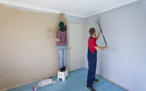 A couple painting a room in their new home.