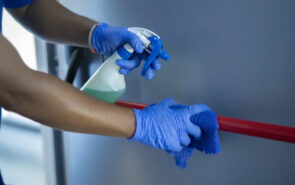 cleaning staff disinfecting the emergency door bar