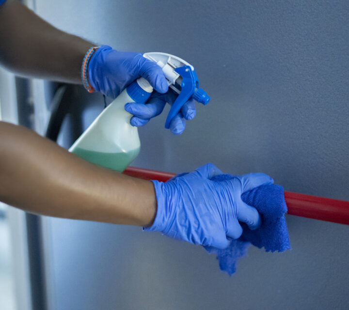 cleaning staff disinfecting the emergency door bar
