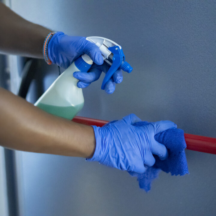 cleaning staff disinfecting the emergency door bar
