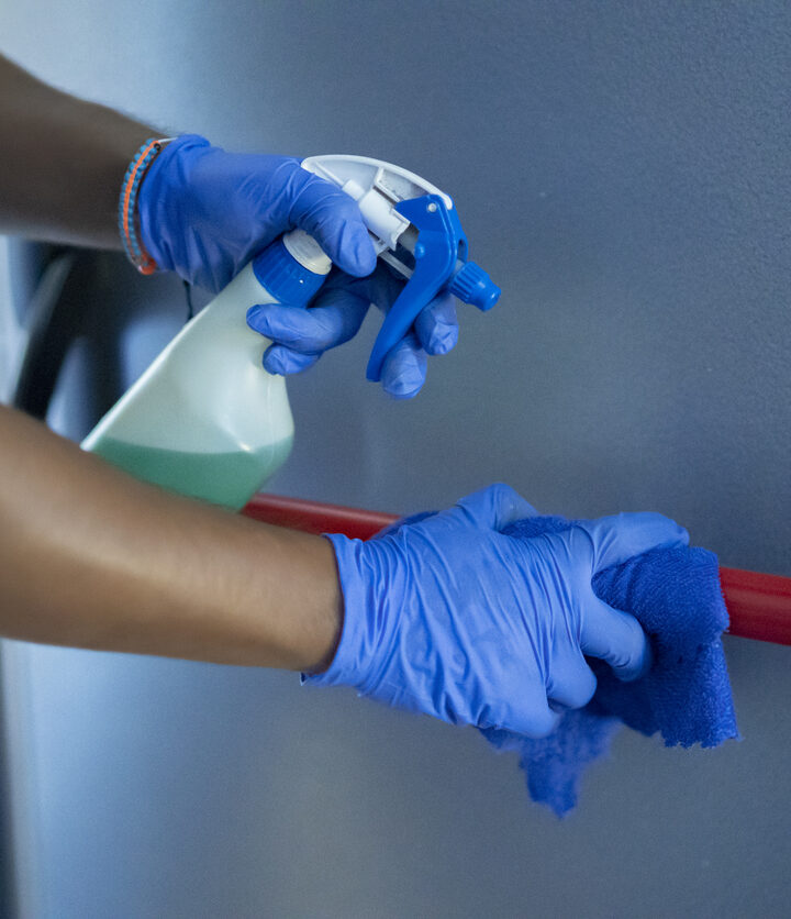 cleaning staff disinfecting the emergency door bar