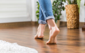 Floor heating. Young woman walking in the house on the warm floor. Gently walked the wooden panels.