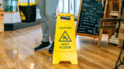 Worker placing wet floor sign after mopping the floor