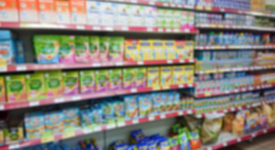 Blurred abstract image. Goods on the shelf of a grocery store. Different baby food.