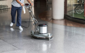 Woman worker cleaning the floor with polishing machine