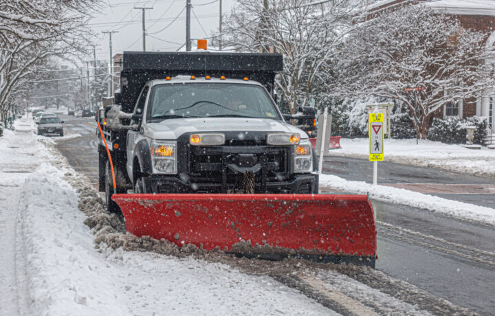 Snow Removal cleaning road during the blizzard snow storm