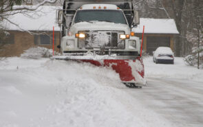 Snow plow removing snow from street.