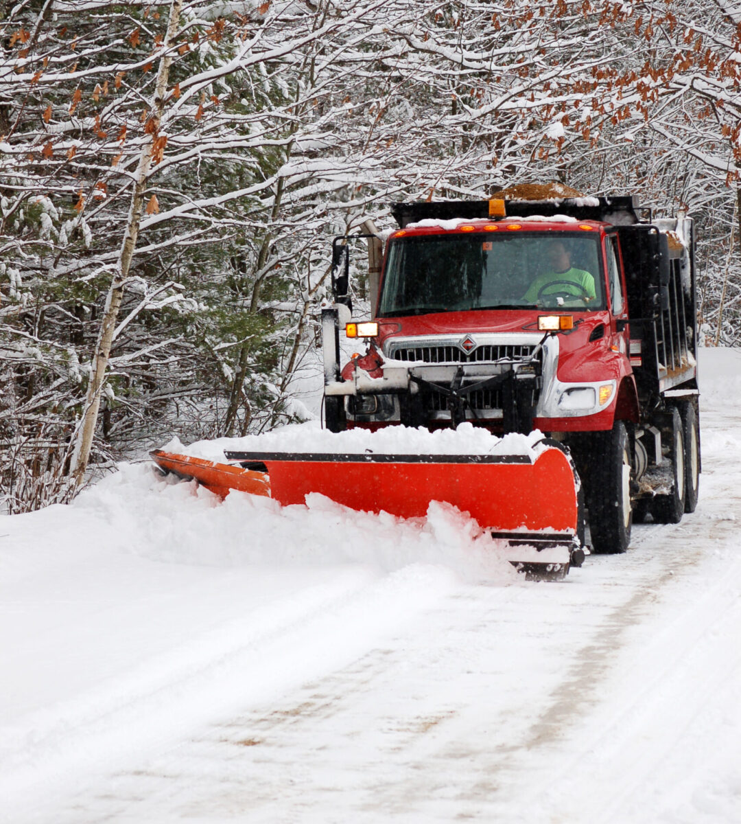 Plowing the snow on a rural road.