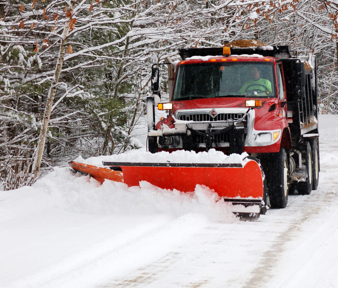 Plowing the snow on a rural road.